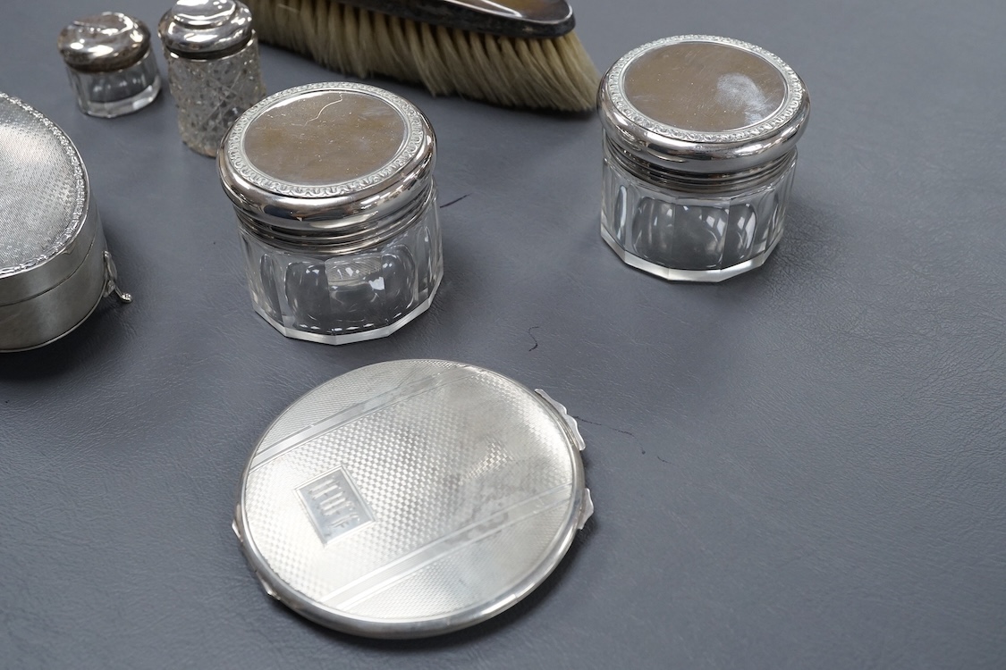 A George V oval silver trinket box, Adie Bros. Birmingham, 1922, 10.8cm, together with a silver compact, four assorted silver mounted toilet jars and a silver mounted hair brush.